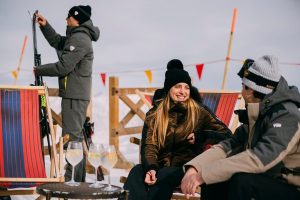A woman and a man laughing together during a relaxing moment while skiing
